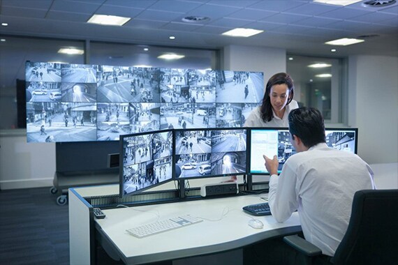Image of workers in a security monitor room.